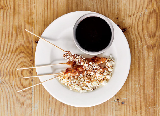 Chicken on sticks with soy sauce and popcorn, as reproduced in Bread is Gold