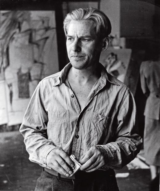 Willem de Kooning in his Fourth Avenue studio with drawings related to Woman I in the background, 1950; photograph by Rudy Burckhardt. Artwork by Willem de Kooning © 2014 The Willem de Kooning Foundation/Artists Rights Society, (ARS), New York