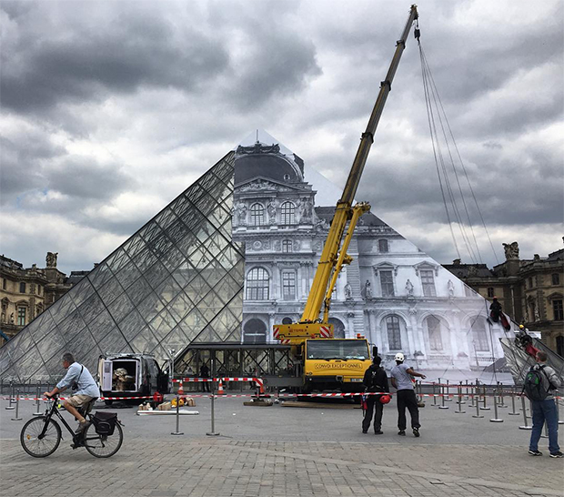 JR's work goes up on the Louvre Pyramid. Image courtesy of JR's Instagram